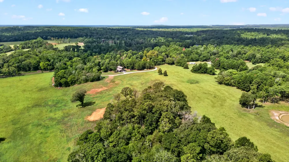 Aerial view toward the residence and surrounding acreage